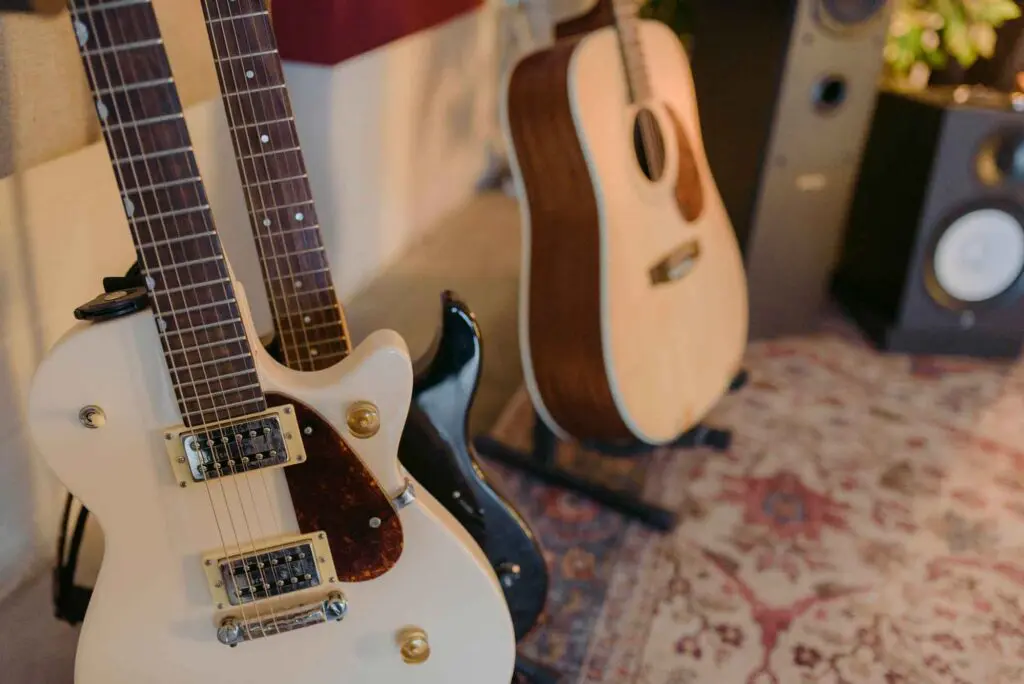 Guitarras acústicas y eléctricas exhibidas juntas, destacando diferentes estilos y modelos en un entorno musical.